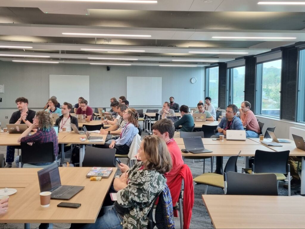 A group of people in a classroom watching a presentation.