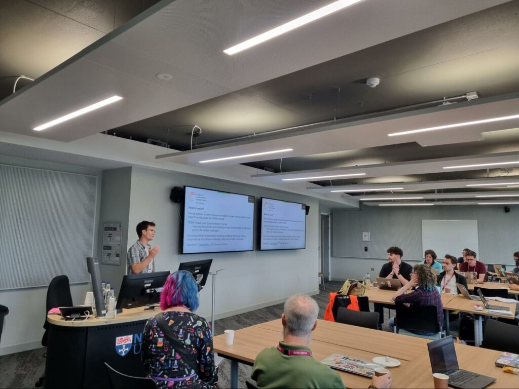 A person standing at a lectern, talking to a room full of people.