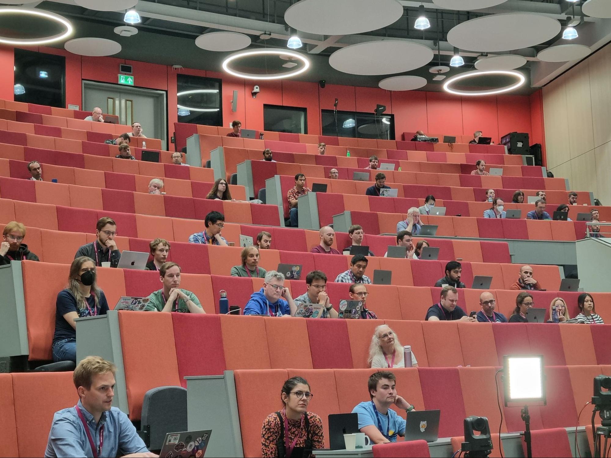 A photo of a lecture theatre full of people watching a presentation.